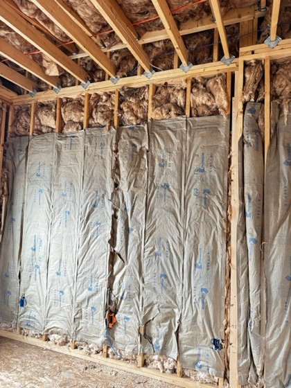 Home runs dropped through the stud bays before insulation closes the wall.