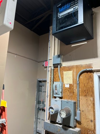 Wall-mounted rack: patch panel, switching, and battery backup, with every run landed and dressed.