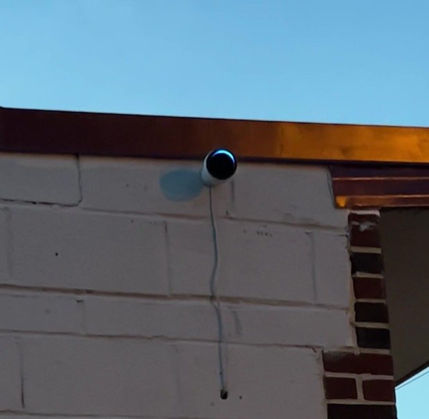 Perimeter camera at the roofline of a commercial building, angled down over the lot.